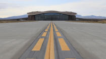 FILE - This Dec. 9, 2014 photo shows the taxiway leading to the hangar at Spaceport America in Upham, N.M. Virgin Galactic is scheduled to unveil the interior of its digs at Spaceport America, providing the first glimpse of mission control, a prep area for pilots and where paying customers will lounge ahead of their suborbital flights. Company officials are gathering Thursday, Aug. 15, 2019, at the remote facility in the New Mexico desert to show off two levels of the custom-tailored hangar at the taxpayer-financed spaceport. (AP Photo/Susan Montoya Bryan, File)