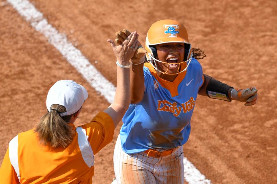 Tennessee’s Kiki Milloy slaps hands with coach Karen Weekly as she rounds the bases during the NCAA softball Knoxville regional final against <a class="link " href="https://sports.yahoo.com/ncaaw/teams/indiana/" data-i13n="sec:content-canvas;subsec:anchor_text;elm:context_link" data-ylk="slk:Indiana;sec:content-canvas;subsec:anchor_text;elm:context_link;itc:0">Indiana</a> on Sunday. Saul Young / USA TODAY NETWORK