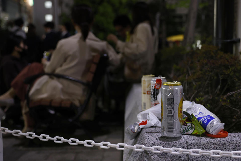 Cans and snacks packages are left as people drink at a park in Tokyo on April 21, 2021. Trains packed with commuters returning to work after a weeklong national holiday. Frustrated young people drinking in the streets because bars are closed. Protests planned over a possible visit by the Olympics chief. As the coronavirus spreads in Japan ahead of the Tokyo Olympics starting in 11 weeks, one of the world’s least vaccinated nations is showing signs of strain, both societal and political. (Kyodo News via AP)
