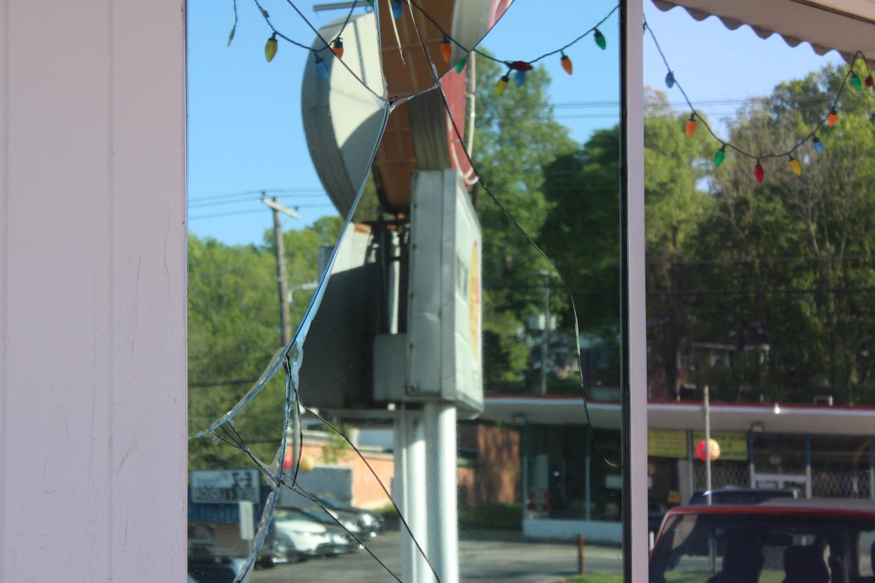 A cracked window reflects the sign for Thai Time. A car crashed into the restaurant at 6200 Chapman Highway.