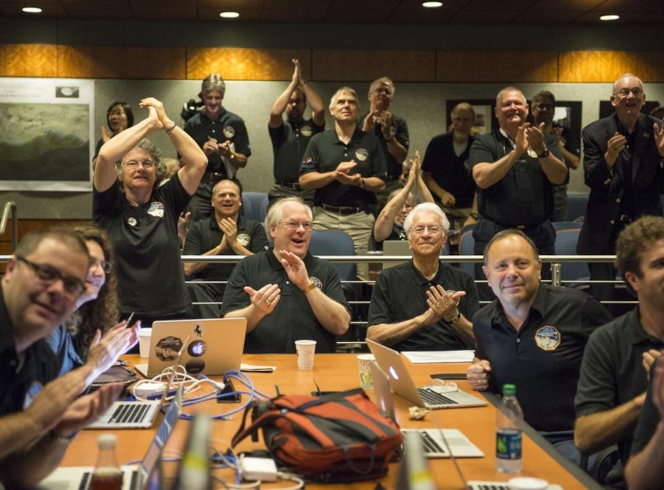 The New Horizons science team reacts to receiving the spacecraft's sharpest image just before it flies by Pluto in July 2015. <cite>Bill Ingalls/NASA</cite>