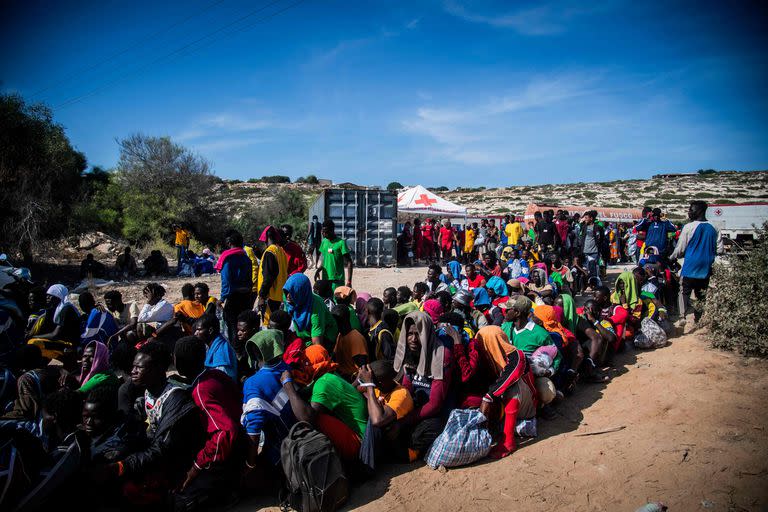 Los migrantes se reúnen frente al centro operativo llamado 