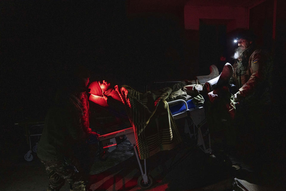 Ukrainian military medics transport their injured comrade evacuated from the battlefield into a hospital in Donetsk region, Ukraine, Monday, Jan. 9, 2023. (AP Photo/Evgeniy Maloletka)