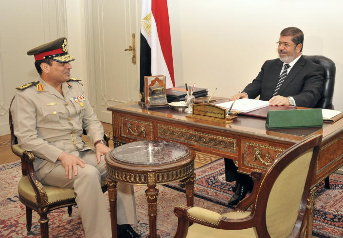 FILE - In this Aug. 22, 2012 file image released by the office of the Egyptian Presidency, Egyptian Minister of Defense, Lt. Gen. Abdel-Fattah el-Sissi, left, meets with Egyptian President Mohammed Morsi at the presidential palace in Cairo, Egypt. The head of Egypt’s military, Abdel-Fattah el-Sissi, is riding on a wave of popular fervor that is almost certain to carry him to election as president. Unknown only two years ago, a broad sector of Egyptians now hail him as the nation’s savior after he ousted the Islamists from power, and the state-backed personality cult around him is so eclipsing, it may be difficult to find a candidate to oppose him if he runs. Still, if he becomes president, he faces the tough job of ruling a deeply divided nation that has already turned against two leaders. (AP Photo/Egyptian Presidency, File)