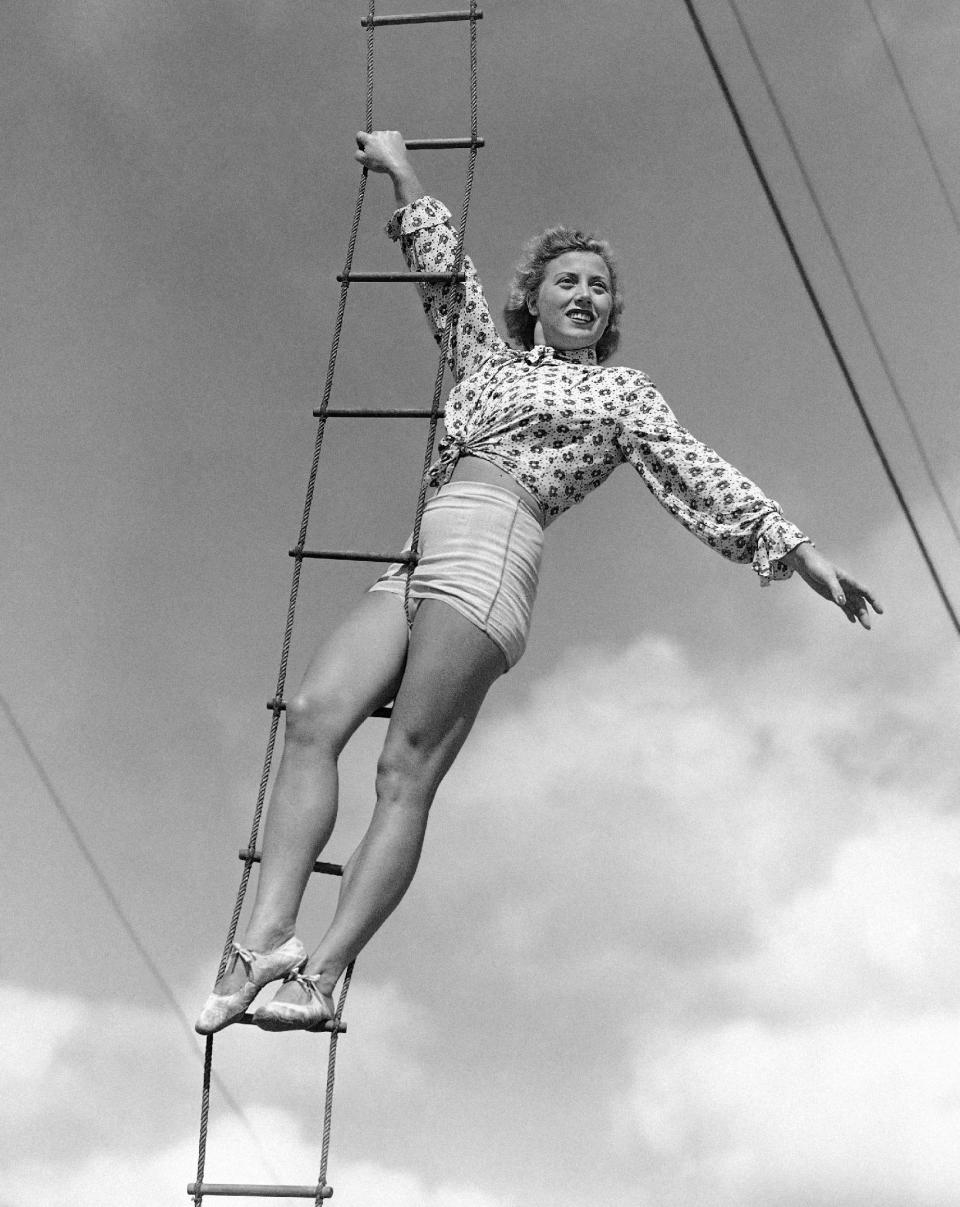 In this Feb. 28, 1945 photo, Elizabeth Wallenda pauses on an aerial ladder during rehearsal for her return to the Wallenda troupe's high wire act with the Ringling Brothers and Barnum and Bailey Circus, now in winter quarters in Sarasota, Fla. The Ringling Bros. and Barnum & Bailey Circus will end "The Greatest Show on Earth" in May 2017, following a 146-year run of performances. Kenneth Feld, the chairman and CEO of Feld Entertainment, which owns the circus, told The Associated Press when the company removed the elephants from the shows in May of 2016, ticket sales declined more dramatically than expected. (AP Photo/Earl Shugars)
