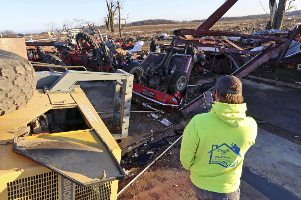 Patrick Crull takes a photo of his flipped vehicle while touring the damage done to his home and farm building on North Tolles Road, Friday morning, Feb. 9, 2024, after a confirmed tornado moved through an area just northwest of Evansville, Wis., the evening before. The tornado was the first-ever reported in February in the state of Wisconsin, according to the National Weather Service. (Anthony Wahl//The Janesville Gazette via AP)