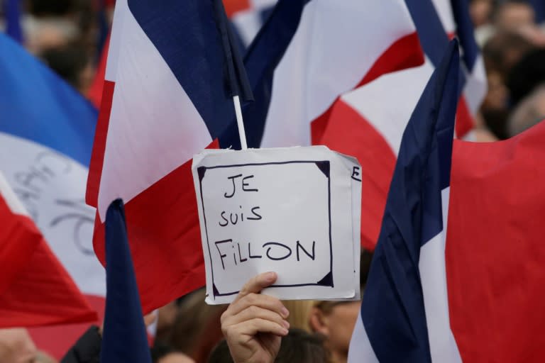 A supporter holds a placard reading "I am Fillon" during a Les Republicains rally in Paris, on March 5, 2017