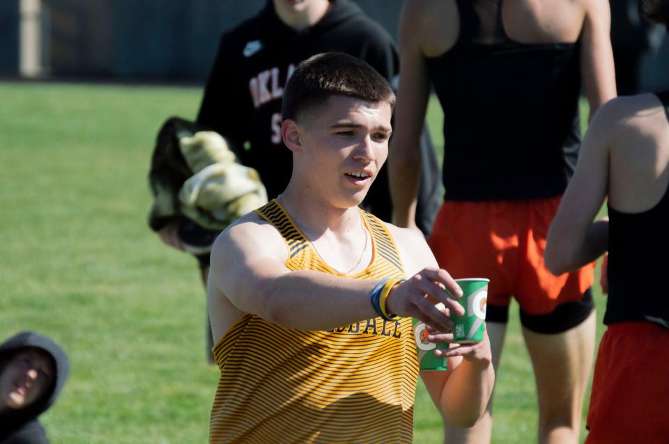 Senior Hunter Wilson has water at-the-ready for his teammate after a hard-fought relay event.