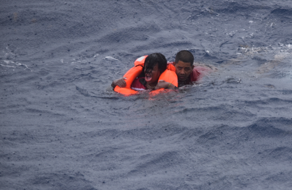 A U.S. Coast Guard crew member swims a woman to safety on Tuesday, July 6, 2021, off Key West. She was among 13 people rescued by the Coast Guard and a merchant vessel crew that afternoon.