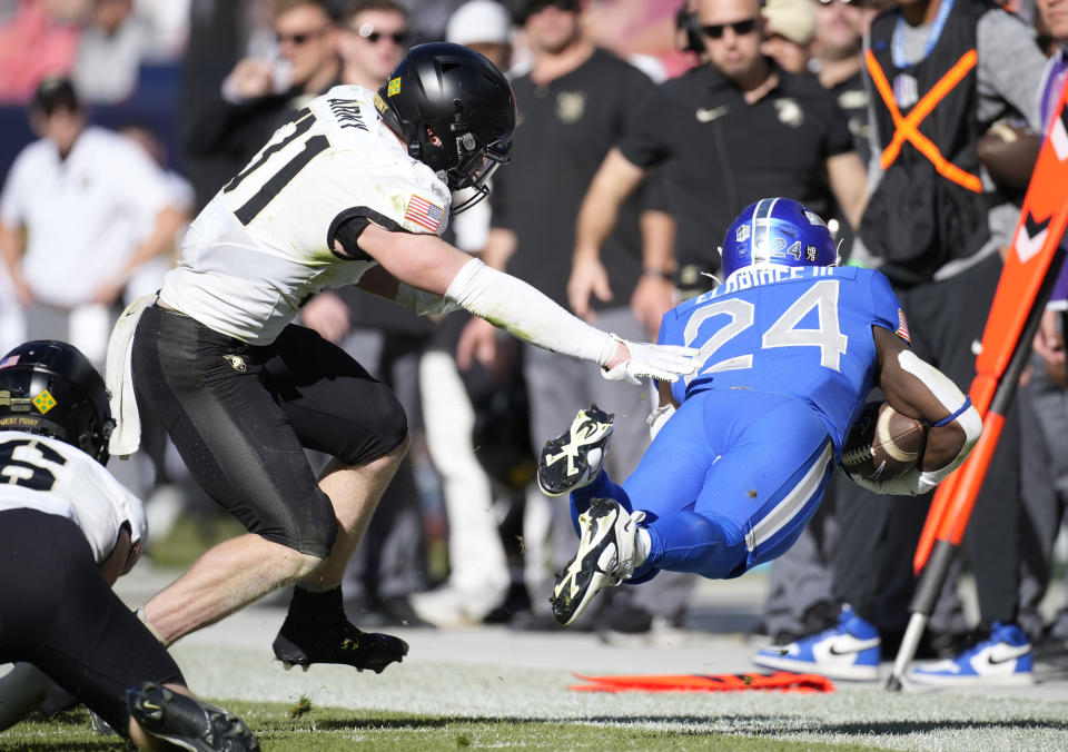 Army linebacker Zane Poulter, left, pushes over Air Force running back John Lee Eldridge III after a short gain in the second half of an NCAA college football game Saturday, Nov. 4, 2023, in Denver. (AP Photo/David Zalubowski)