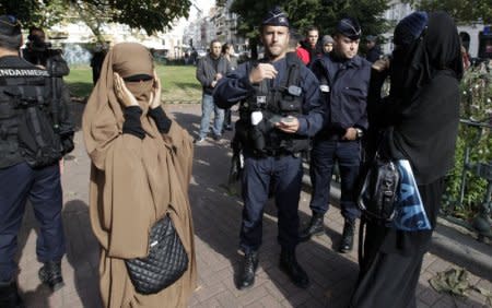 FILE PHOTO: French police and gendarmes check identity cards of two women for wearing full-face veils, or niqab, as they arrived to demonstrate after calls on the internet by Islamic groups to protest over an anti-Islam video, in Lille September 22, 2012. REUTERS/Pascal Rossignol