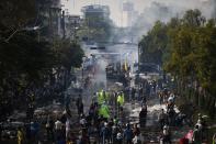 Clouds of teargas are seen at the barricade near the Government House where anti-government protesters and police clash in Bangkok December 2, 2013. Thai Prime Minister Yingluck Shinawatra said on Monday she would "open every door" to find a peaceful solution to a political crisis gripping Bangkok as police used rubber bullets against protesters seeking to topple her government. REUTERS/Damir Sagolj