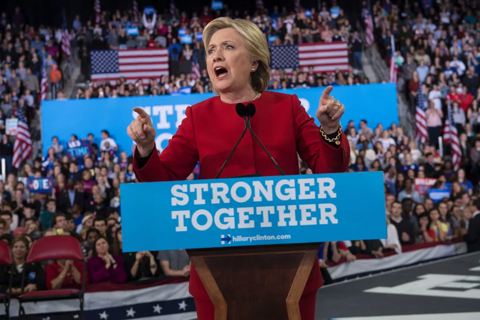 Then-Democratic presidential nominee Hillary Clinton at a rally in 2016 from a podium bearing the sign