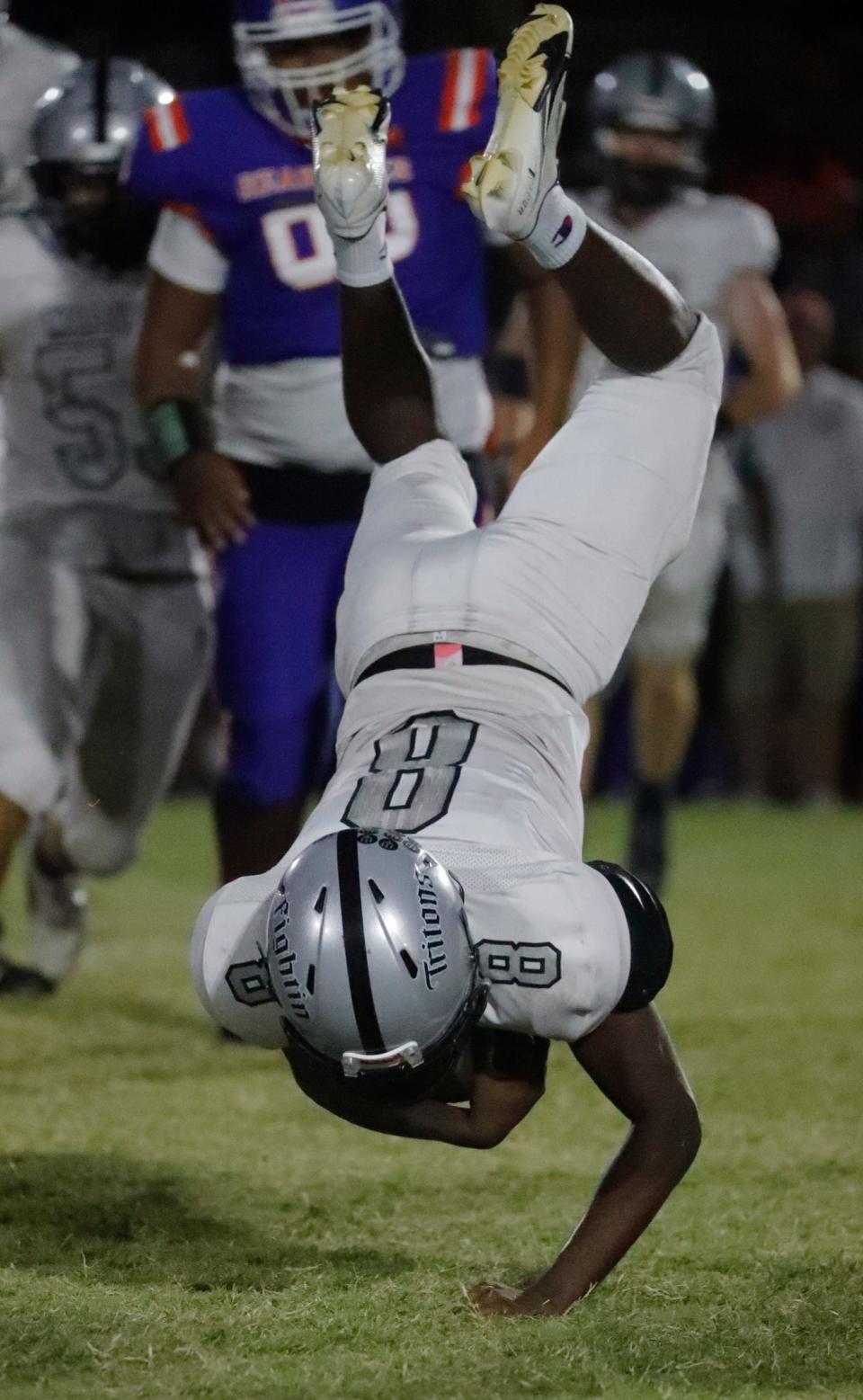 Running back Jamauris Woolfork gets flipped after being tackled during a run. The Mariner Tritons visited the Cape Coral High School Seahawks Thursday, October 27, 2022 in a rivalry matchup.