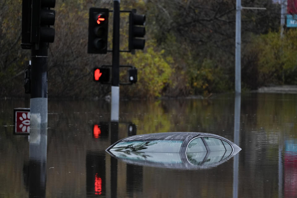 A car sits along a flooded road during a rain storm Monday, Jan. 22, 2024, in San Diego. Heavy rainfall around the U.S. on Monday prompted first responders in Texas to conduct water rescues and officials in California to issue evacuation warnings over potential mudslides in parts of Los Angeles County. (AP Photo/Gregory Bull)