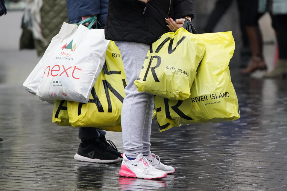 Shoppers carry bulging bags from River Island and Next in Liverpool city centre on Black Friday. Photo: PA