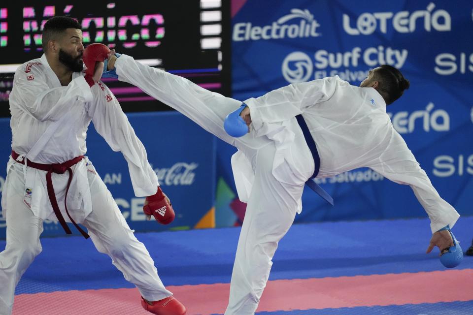 El dominicano Anel Castillo repele una patada del colombiano Diego Lenis en el combate de karate, división de más de 84 kilogramos, de los Juegos Centroamericanos y del Caribe en San Salvador, el sábado 8 de julio de 2023 (AP Foto/Arnulfo Franco)