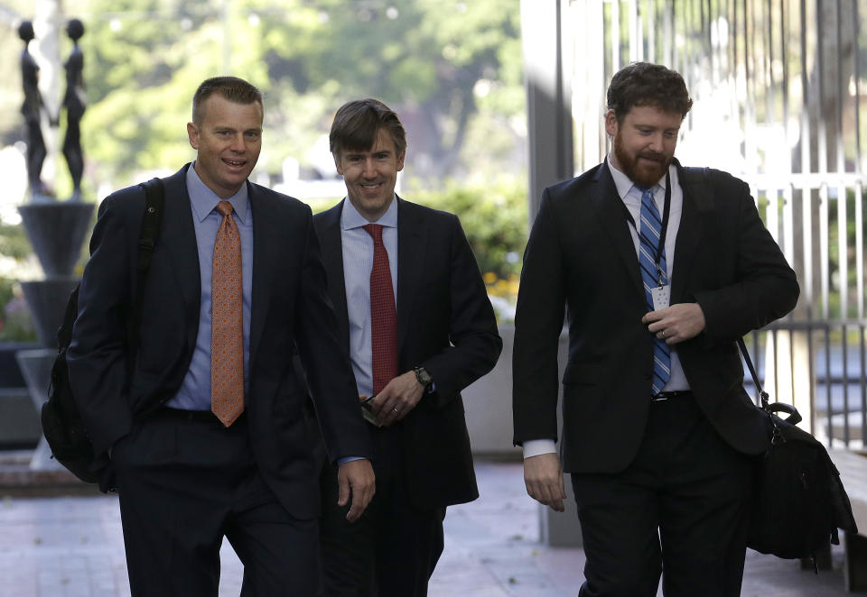 Samsung attorney David Nelson, left, walks with others to a federal courthouse in San Jose, Calif., Tuesday, April 29, 2014. The Silicon Valley court battle between Apple and Samsung is entering its final phase. Lawyers for both companies are expected to deliver closing arguments Tuesday before jurors are sent behind closed doors to determine a verdict in a closely watched trial over the ownership of smartphone technology. (AP Photo/Jeff Chiu)