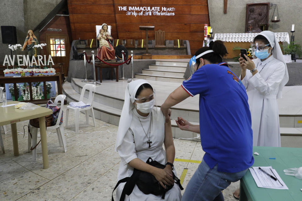 A Catholic nun is inoculated with AstraZeneca COVID-19 vaccine at the Immaculate Heart of Mary Parish Church that turned into a temporary vaccination center in Quezon City, Philippines on Friday, May 21, 2021. Philippine officials have been ordered not to disclose in advance the COVID-19 vaccine brands to be administered in immunization sites after those offering newly arrived Pfizer shots drew big crowds in what could be an indication of public preference for Western vaccines. (AP Photo/Aaron Favila)
