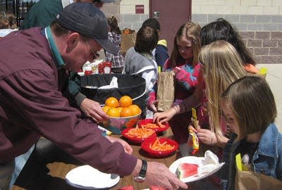 Eaton Rapids Public Schools superintendent Bill DeFrance (l) helps serve a healthy lunch to elementary children April 29, 2011, at the high school's Earth Day.