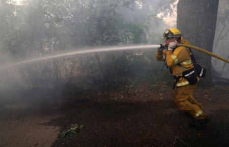 A firefighter knocks down hotspots to slow the spread of the River Fire (Mendocino Complex) in Lakeport, July 31, 2018. REUTERS/Fred Greaves