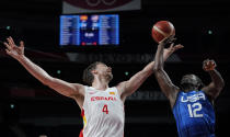 Spain's Pau Gasol (4) and United States' Jrue Holiday (12) fight for a rebound during men's basketball quarterfinal game at the 2020 Summer Olympics, Tuesday, Aug. 3, 2021, in Saitama, Japan. (AP Photo/Charlie Neibergall)