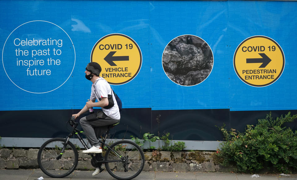 A cyclist passes an advertising board in Bolton, England. (Christopher Furlong/Getty Images)