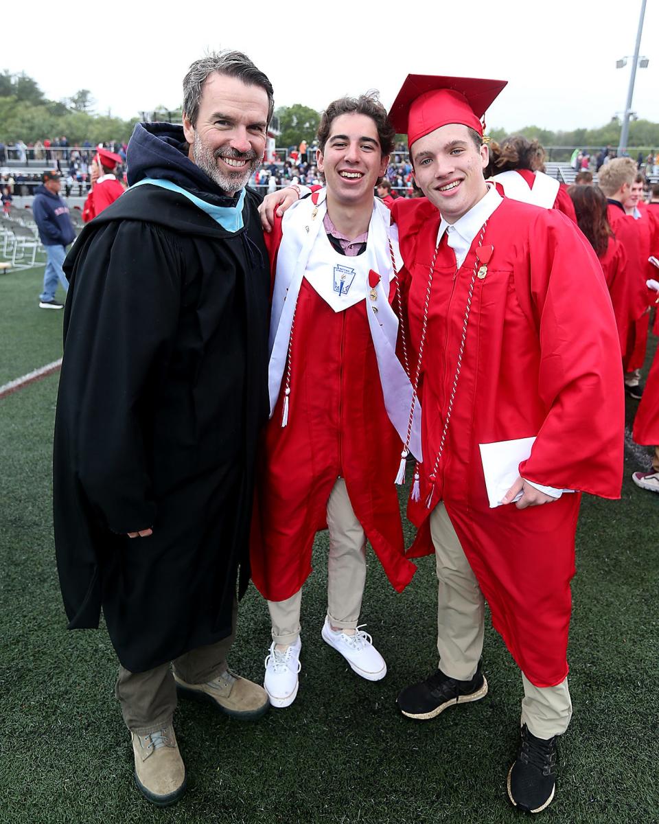 Michael Renna and Tommy Kennedy pose for a photo with history and business teacher Steven George during Hingham High’s graduation ceremony for the Class of 2023 on Saturday, June 3, 2023.