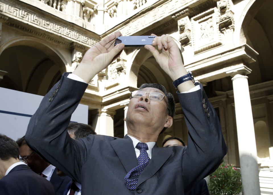 Chinese Minister of Finance Liu Kun, takes pictures on the occasion of the Italy-China Financial forum, at Palazzo Marino town hall, in Milan, Italy, Wednesday, July 10, 2019. (AP Photo/Luca Bruno)