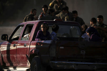 People are seen fleeing Raqqa on the back of a truck. REUTERS/ Rodi Said