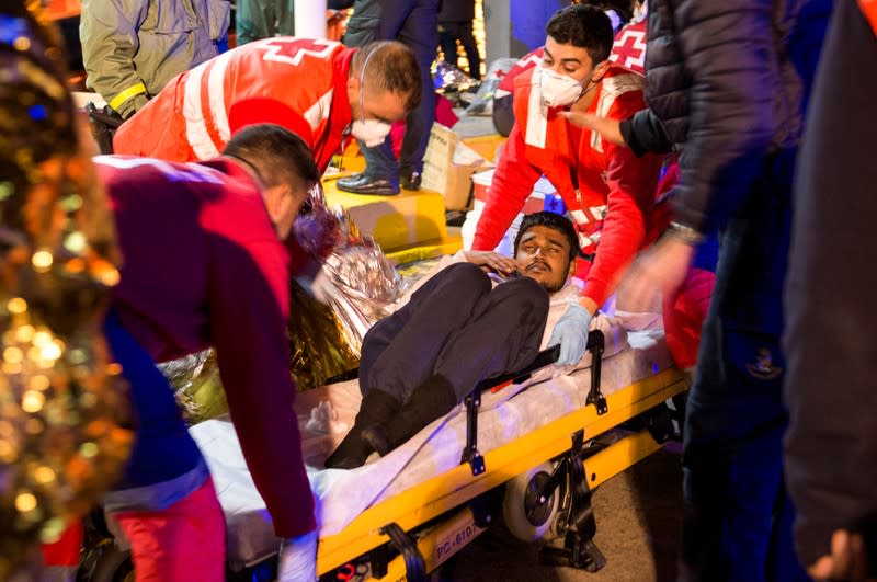 Members of the Spanish Red Cross help a migrant, after a rescue action off the coast at the Mediterranean Sea, at the port of the Spanish North African enclave of Melilla