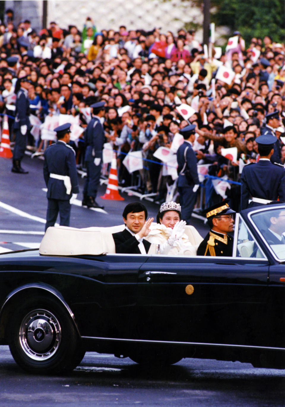 FILE - In this June 9, 1993, file photo, then Crown Prince Naruhito and Princess Masako wave to well-wishers from a limousine during a parade through the streets of Tokyo following their wedding at the Imperial Palace. Japan is abuzz ahead of a ceremony Tuesday, Oct. 22, 2019, marking Emperor Naruhito’s ascension to the Chrysanthemum Throne. It is one of several formal ceremonies for Naruhito, 59, who has been a full-fledged emperor since succeeding in May after the abdication of his father, Akihito.(AP Photo/Tsugufumi Matsumoto, File)