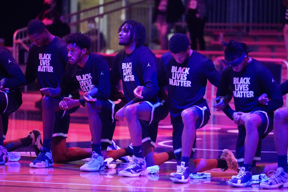 The Georgetown basketball team takes a knee during the national anthem before an NCAA college basketball game against Butler, Wednesday, Jan. 6, 2021, in Indianapolis. (AP Photo/Darron Cummings)