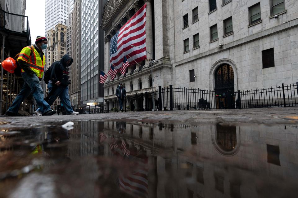 Two  men wearing a masks walks pass  the New York Stock Exchange (NYSE) on April 30, 2020 in New York City. - Wall Street stocks opened lower Thursday following another spike of jobless claims in the wake of coronavirus shutdowns, offsetting strong results from tech giants. Another 3.84 million US workers filed for unemployment benefits last week and the total has now passed 30 million in six weeks, according to the Labor Department data. (Photo by Johannes EISELE / AFP) (Photo by JOHANNES EISELE/AFP via Getty Images)