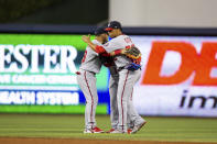 Washington Nationals left fielder Juan Soto (22) shares a hug with his fellow outfielders after defeating the Miami Marlins a baseball game on Thursday, June 24, 2021, in Miami.. (AP Photo/Mary Holt)