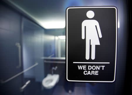 A sign protesting a recent North Carolina law restricting transgender bathroom access adorns the bathroom stalls at the 21C Museum Hotel in Durham, North Carolina May 3, 2016. REUTERS/Jonathan Drake/File Photo