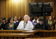 Media look at photographs of the crime scene at the home of Oscar Pistorius in court during his murder trial in Pretoria, South Africa, Friday, March 14, 2014. Pistorius is charged with the shooting death of his girlfriend Reeva Steenkamp, on Valentines Day in 2013. (AP Photo/Kim Ludbrook, Pool)