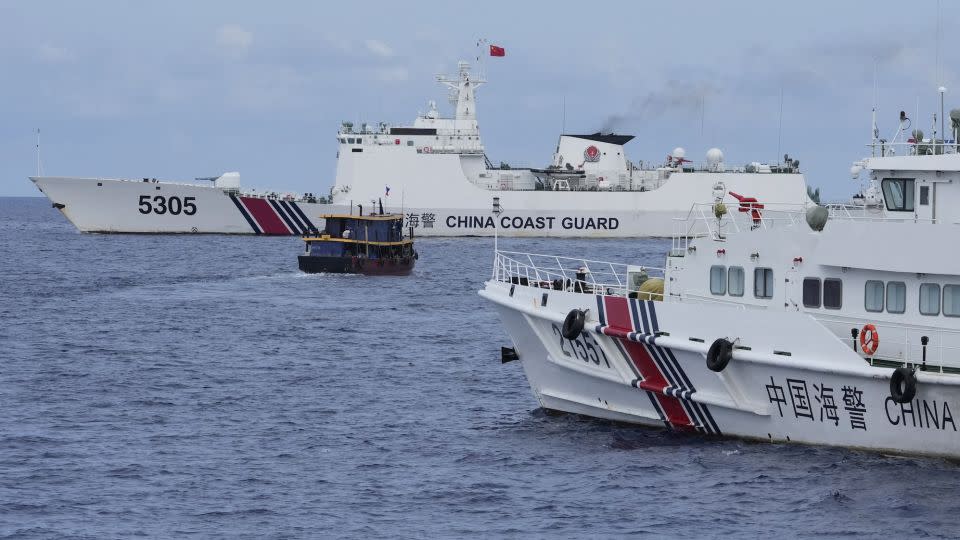 A Philippine supply boat, center, maneuvers around Chinese coast guard ships as they tried to block its way near Second Thomas Shoal, locally known as Ayungin Shoal, at the disputed South China Sea on August 22. - Aaron Favila/AP