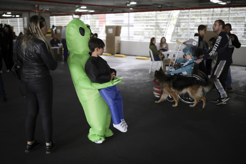 Niños disfrazados acompañan a su madre a votar en las elecciones locales y regionales en Bogotá, Colombia, el domingo 29 de octubre de 2023. (Foto AP/Iván Valencia)