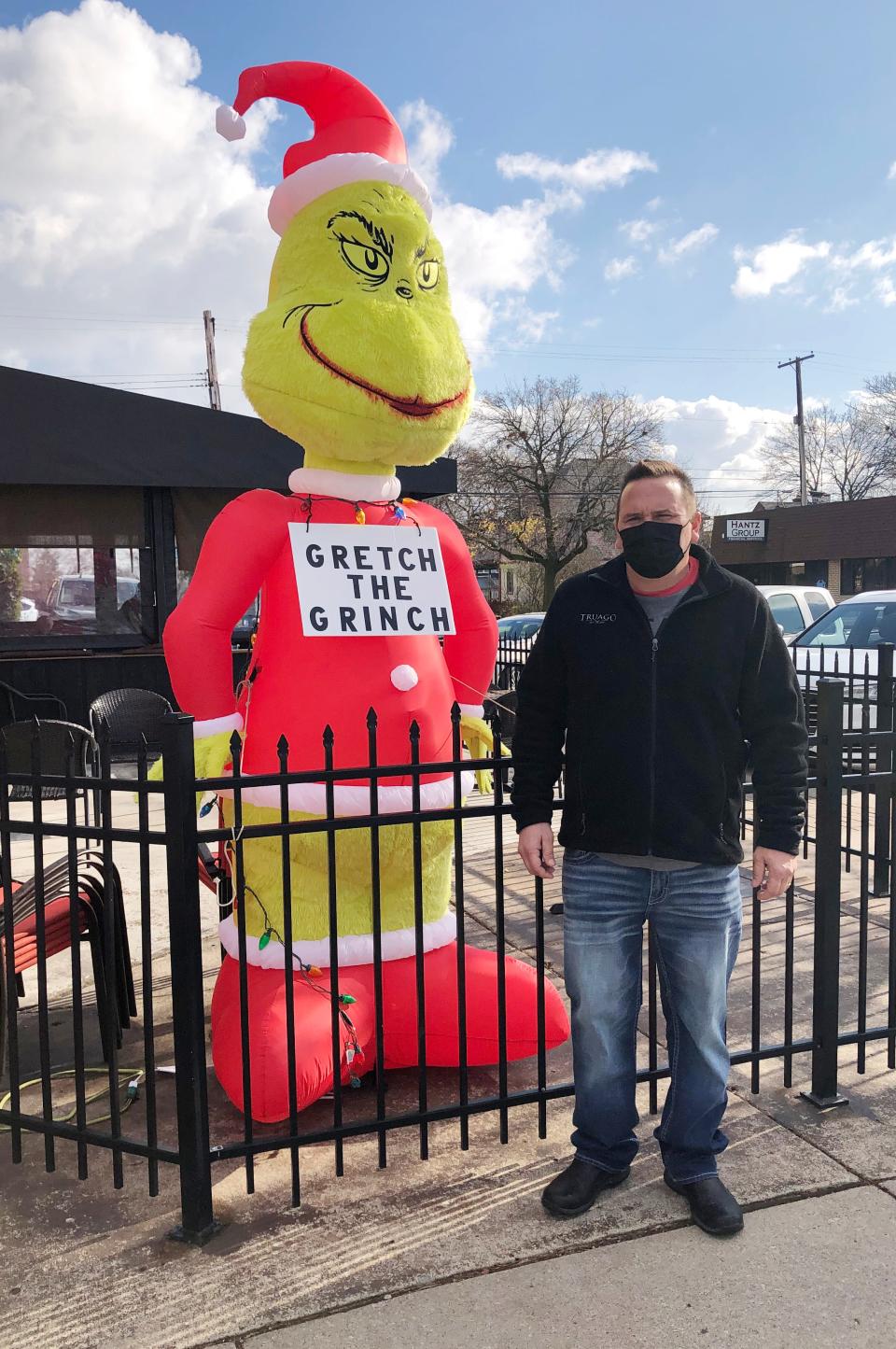 Jeremy Syrocki, owner of Truago in Trenton, Mich., protests the latest restaurant shutdown with a Grinch inflatable aimed at Gov. Gretchen Whitmer.