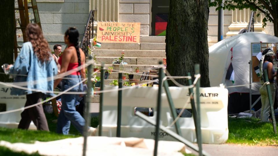 People walk past the remnants of an encampment of tents in Harvard Yard on the campus of Harvard University, Tuesday, May 14, 2024, in Cambridge, Mass (AP)