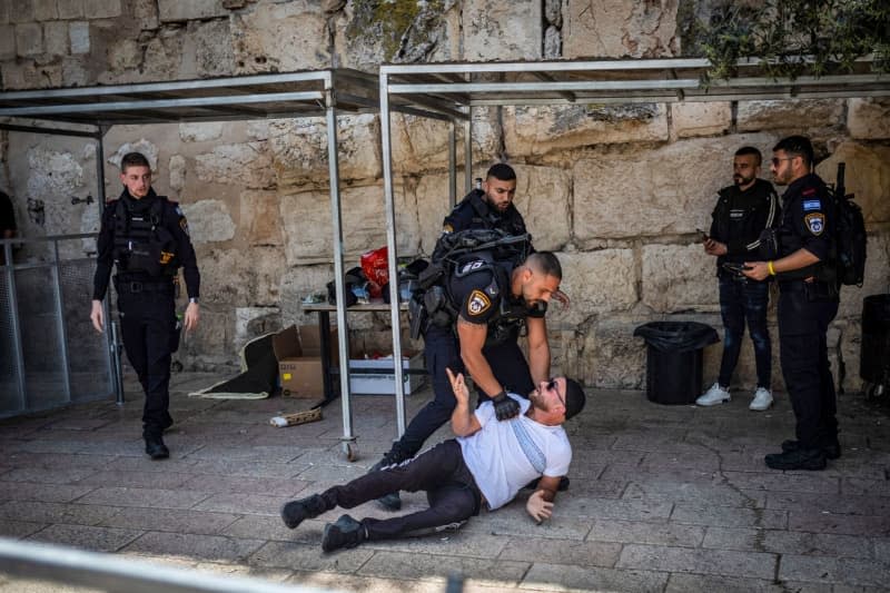 Israeli forces arrest man as Muslim worshippers gather in the old city on the last Friday of the holy month of Ramadan, ahead of Laylat-al-Qadr (the night of destiny), believed in Islam to be the night when the Quran was first revealed to the Prophet Muhammad. Ilia Yefimovich/dpa