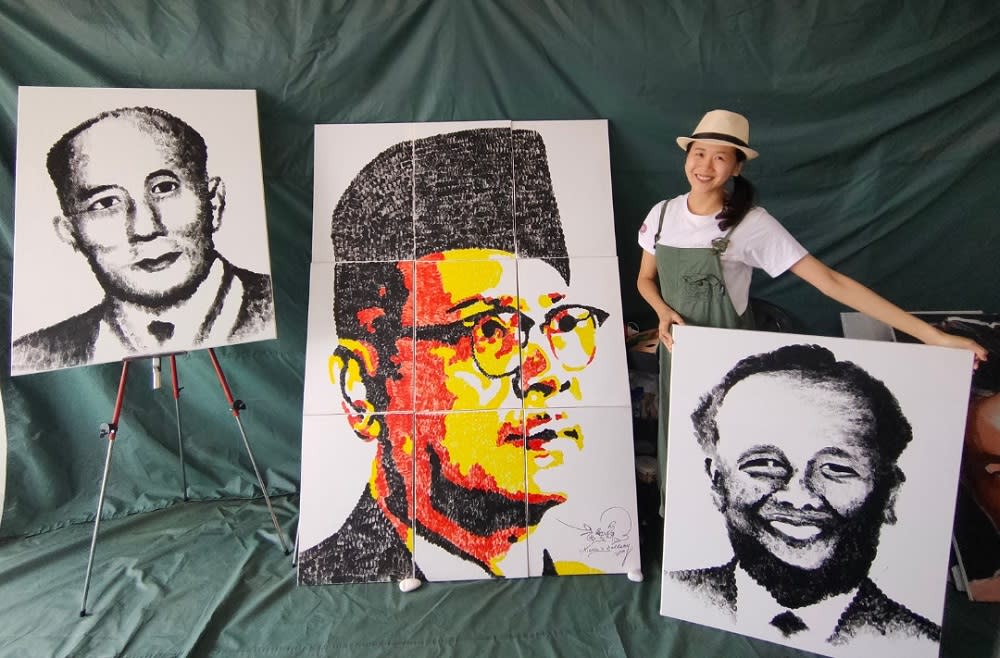 Vivian Ng together with her thumbprint portraits of Tun Tan Cheng Lock, Tunku Abdul Rahman and Tun VT Sambanthan. — Picture courtesy of Vivian Ng