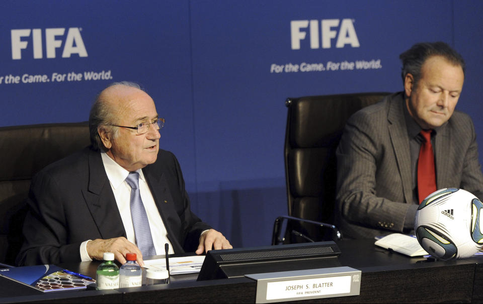 FILE - FIFA President Joseph Sepp Blatter, left, and Mark Pieth, Chairman of the Independent Governance Committee, right, speak during a press conference at the Home of FIFA in Zurich, on Nov. 30, 2011. The Olympics and international soccer once lived through very public corruption crises. The International Olympic Committee had the Salt Lake City bidding scandal. Soccer faced waves of bribery allegations in 2015 that removed the FIFA and UEFA presidents. In crisis they agreed to limit presidents to 12 years in office to help curb power cliques. This rule now faces pushback. (Walter Bieri/Keystone via AP, File)