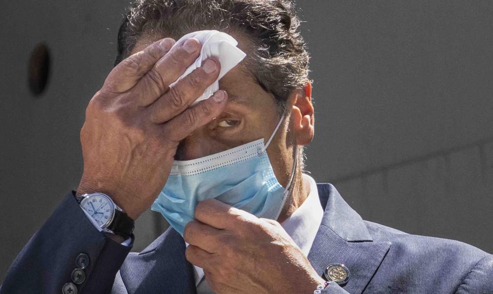 FILE - This photo from Monday, Aug. 3, 2020, shows New York Gov. Andrew Cuomo wiping sweat from his face during a ceremony at the St. Nicholas Greek Orthodox Church at the World Trade Center in New York. Facing unprecedented political isolation, New York Gov. Andrew Cuomo is insisting he won't step down after allegations of sexual harassment. (AP Photo/Mark Lennihan, File)