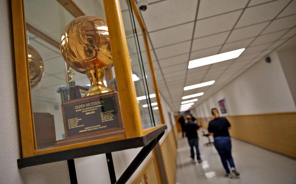 A trophy from the 2009-2010 junior high basketball season sits in a case just outside the gym at the Olfen school on Friday, Jan. 24, 2020.