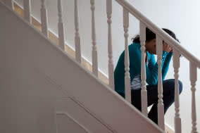 BE6G97 Unidentified Female sitting on the stairs with her head in hands.Keywords : women, depression, relationships, alone, div