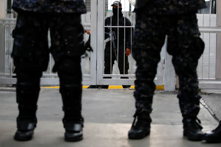 Members of Bolivarian National Intelligence Service (SEBIN) stand guard as mourners of the municipal lawmaker Fernando Alban gather outside its headquarters in Caracas, Venezuela October 8, 2018. REUTERS/Carlos Garcia Rawlins