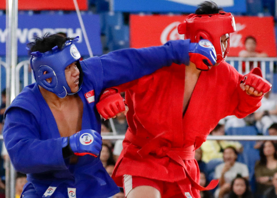 Singapore's Nazri Sutari (left) lands a punch on Indonesia's Jason Sim en route to winning gold in the men's combat sambo U-82kg. (PHOTO: Sport Singapore)