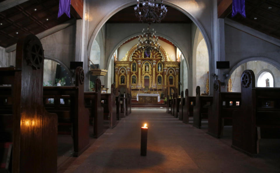 A lit candle is seen in the middle aisle of the damage of St. Catherine church following a 6.1 magnitude earthquake is seen in Porac township, Pampanga province, north of Manila, Philippines Tuesday, April 23, 2019. The strong earthquake struck the northern Philippines Monday trapping some people in a collapsed building, damaged an airport terminal and knocked out power in at least one province, officials said. (AP Photo/Bullit Marquez)